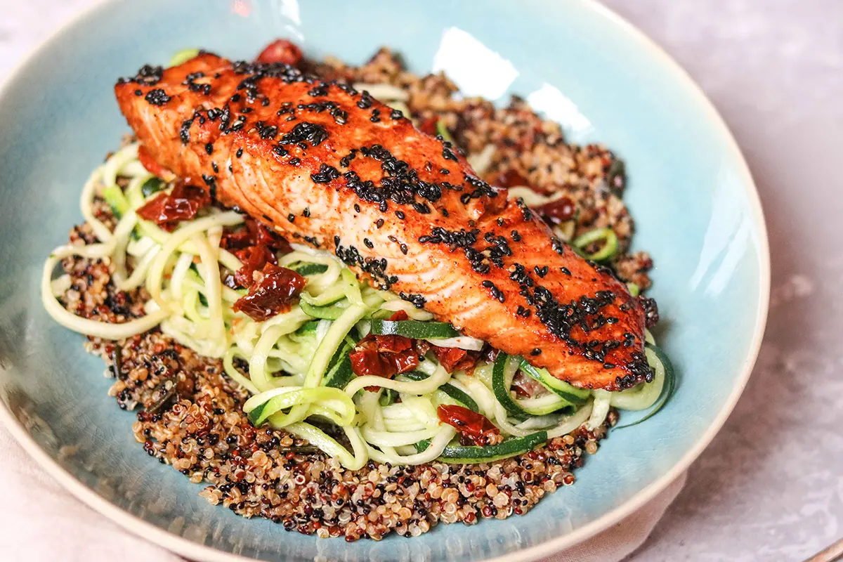 A plate of oven-baked salmon with zoodles and quinoa